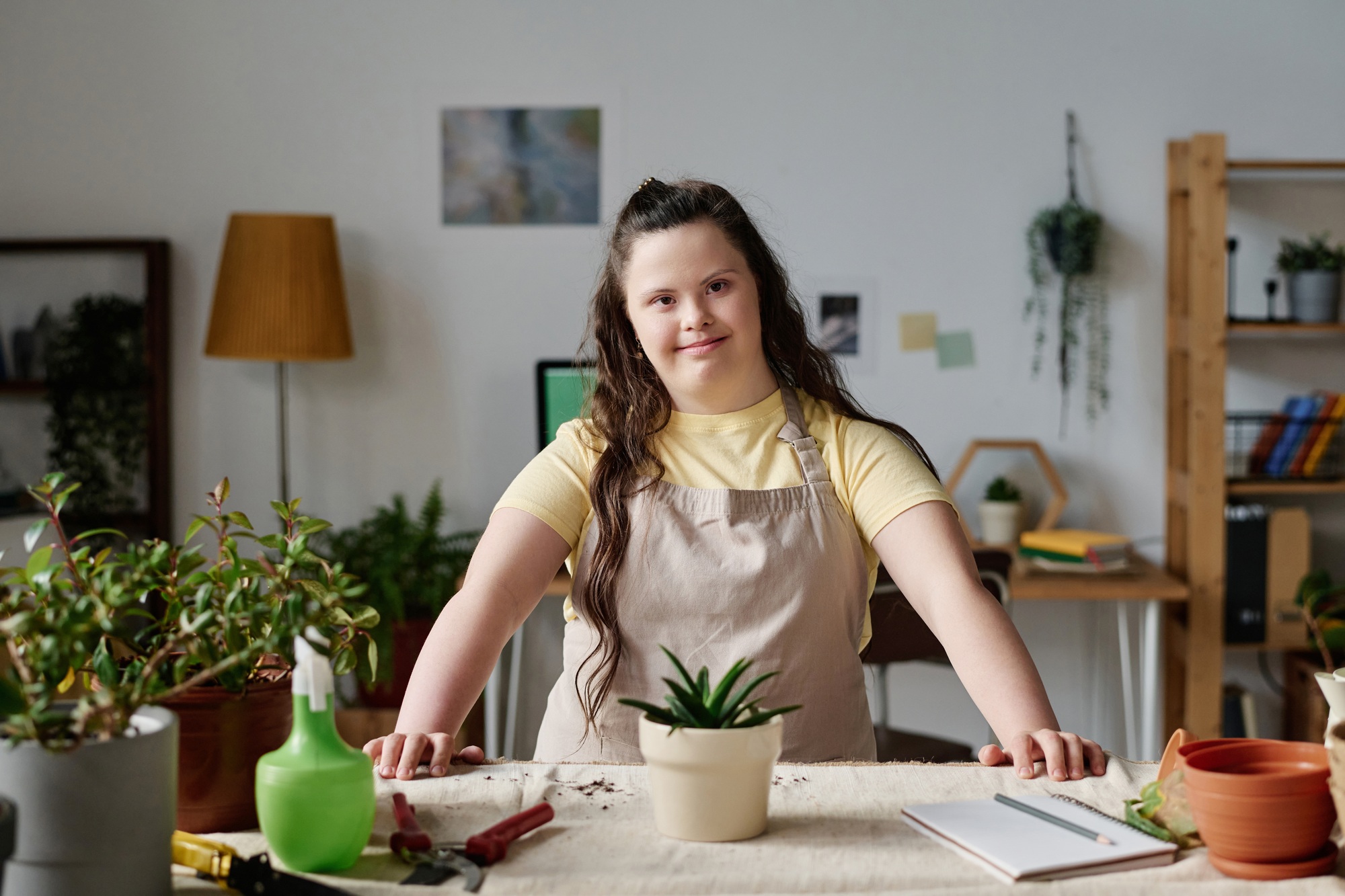 Girl with down syndrome planting plants in pots